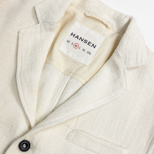 Hansen Garments Charlie Three Button Blazer - Off White Gauze - product shot - front facing - close up detail of brand tag, collar, and button - white backdrop