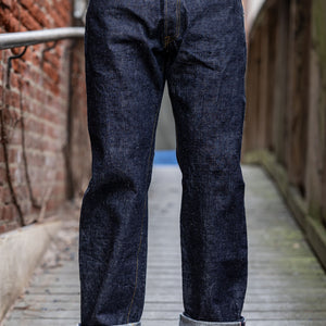 A person standing on a wooden platform wearing a pair of Samurai S3100VX 'Zero' WWII model wide straight jeans with a dark blue rinse.