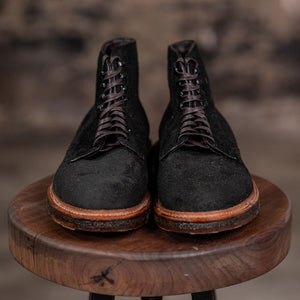 Alden Plain Toe boots on a wooden stool with a blurred background - front view