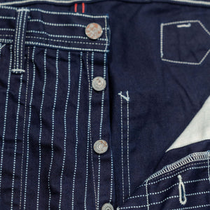 Navy striped fatigue pocket pants close up on open button fly laying flat
