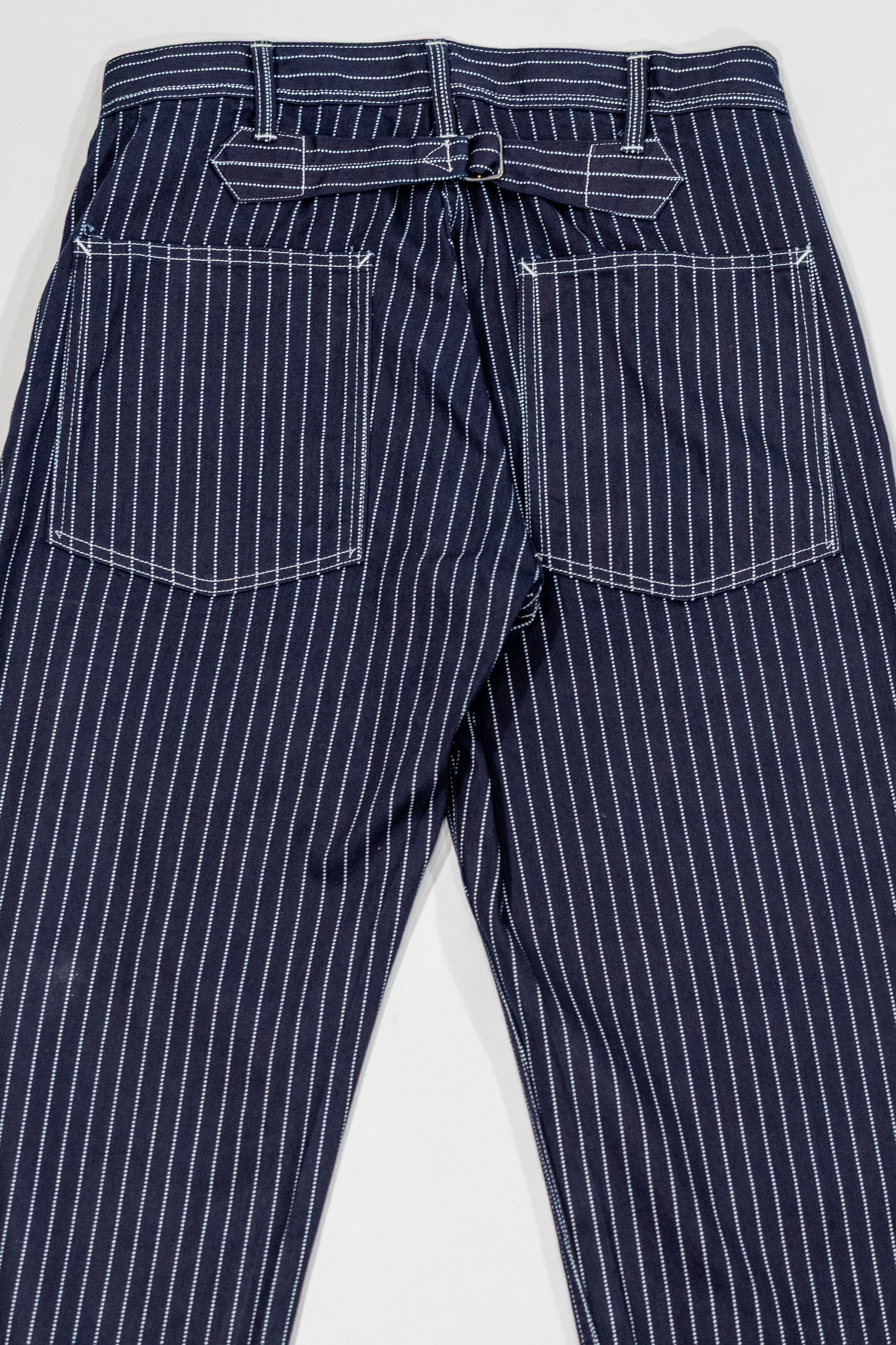 Navy striped fatigue pocket pants with cinch buckle rear, back view laying flat