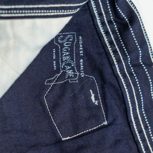 Navy striped fatigue pocket pants close up on solid navy interior and internal Sugar Cane branding laying flat