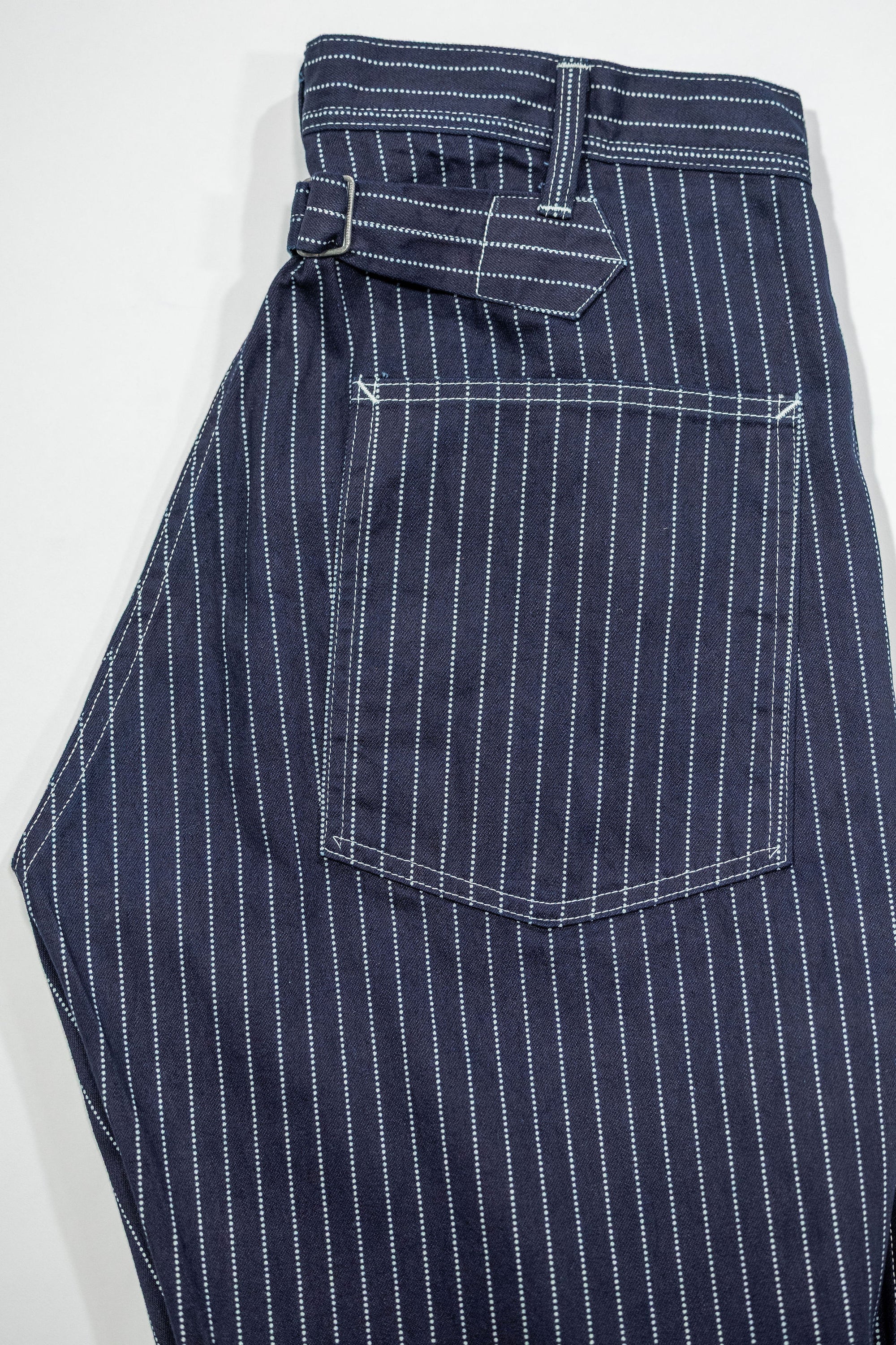 Navy striped fatigue pocket pants back pocket and cinch, folded laying flat