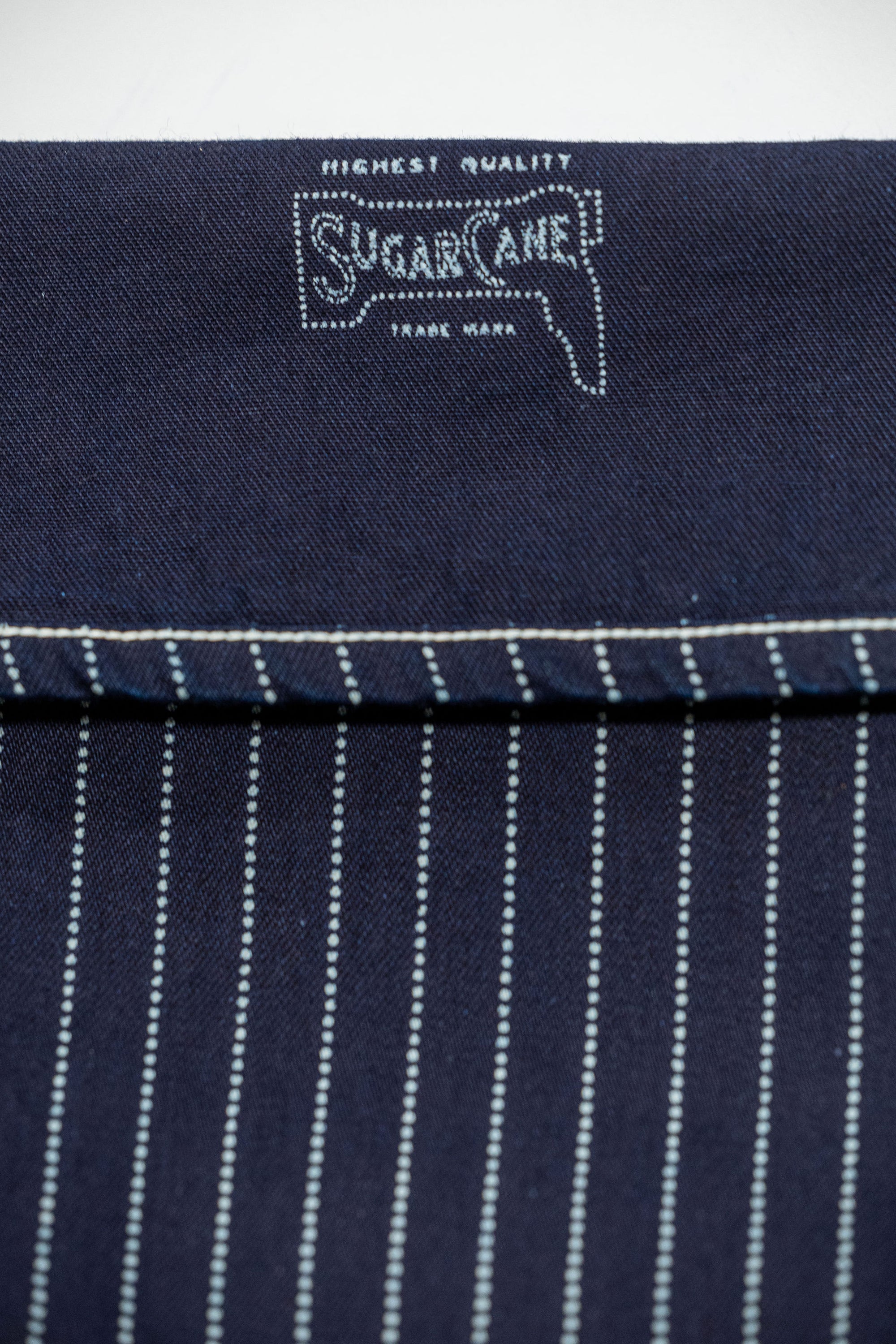 Navy striped fatigue pocket pants close up on cuffed hem with navy interior and Sugar Casne branding