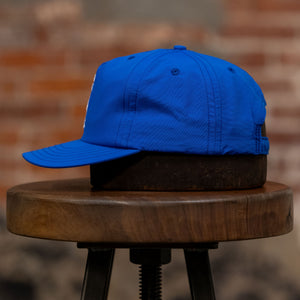 Franklin & Poe Surf Cap - Nylon Royal Blue on stool, facing the side