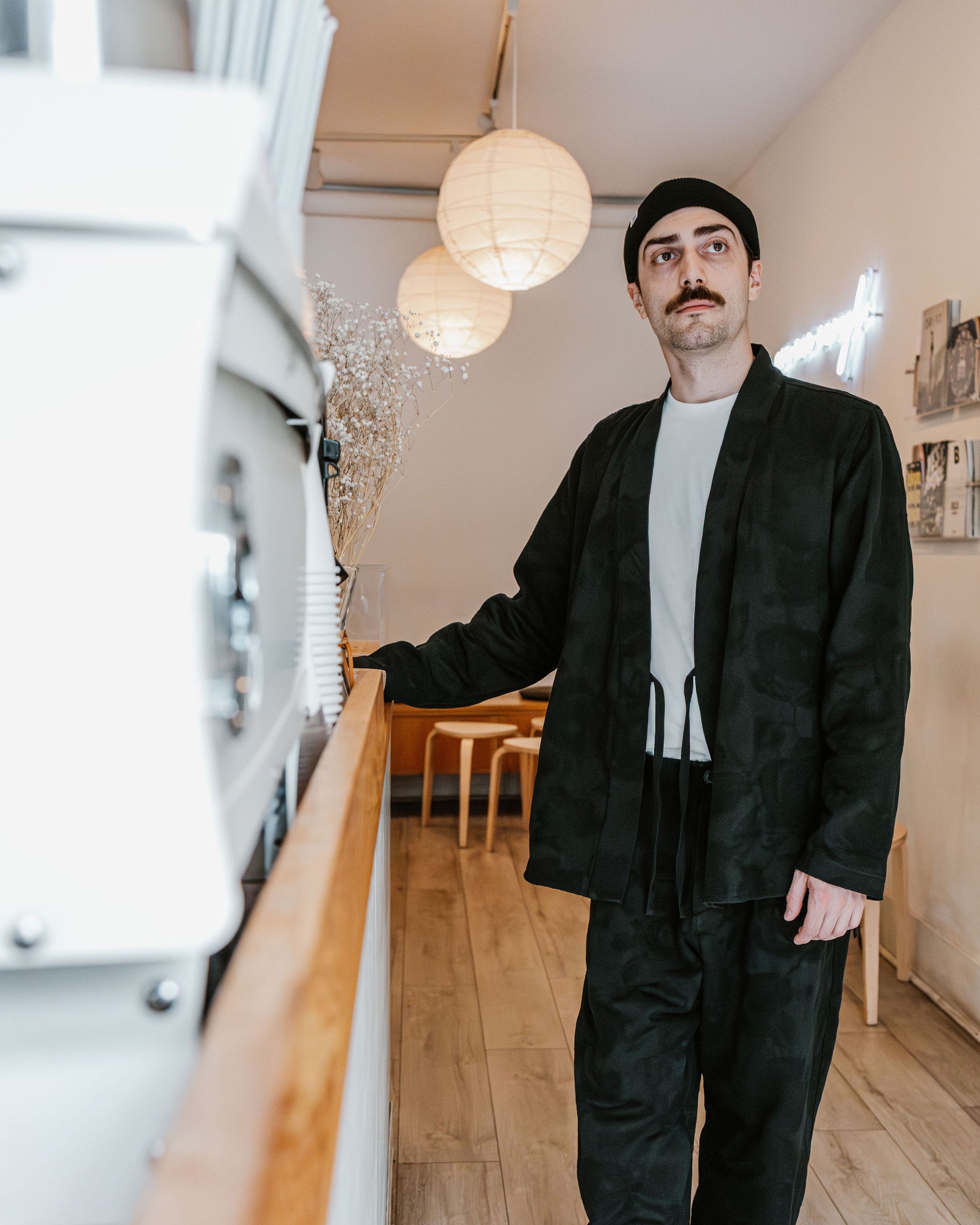 Hansen Garments Roman Loose Cut Jacket - Black Flowers - model shot - front facing - cafe background
