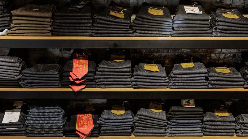 The denim wall at Franklin and Poe featuring stacks of folded denim