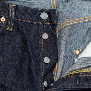 Indigo denim jeans wide cut front view laying flat closeup on open fly