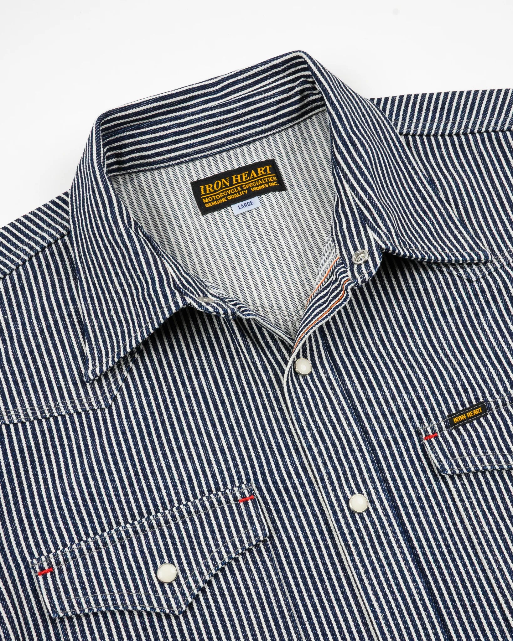 Western style shirt with indigo and white thin vertical stripes and white snaps front view close-up second angle laying flat
