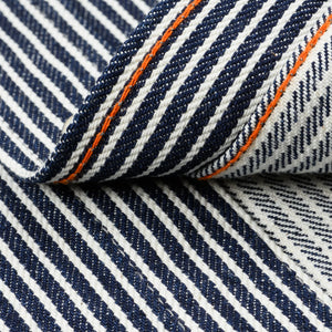 Western style shirt with indigo and white thin vertical stripes close-up on fabric and orange bottom stitch 