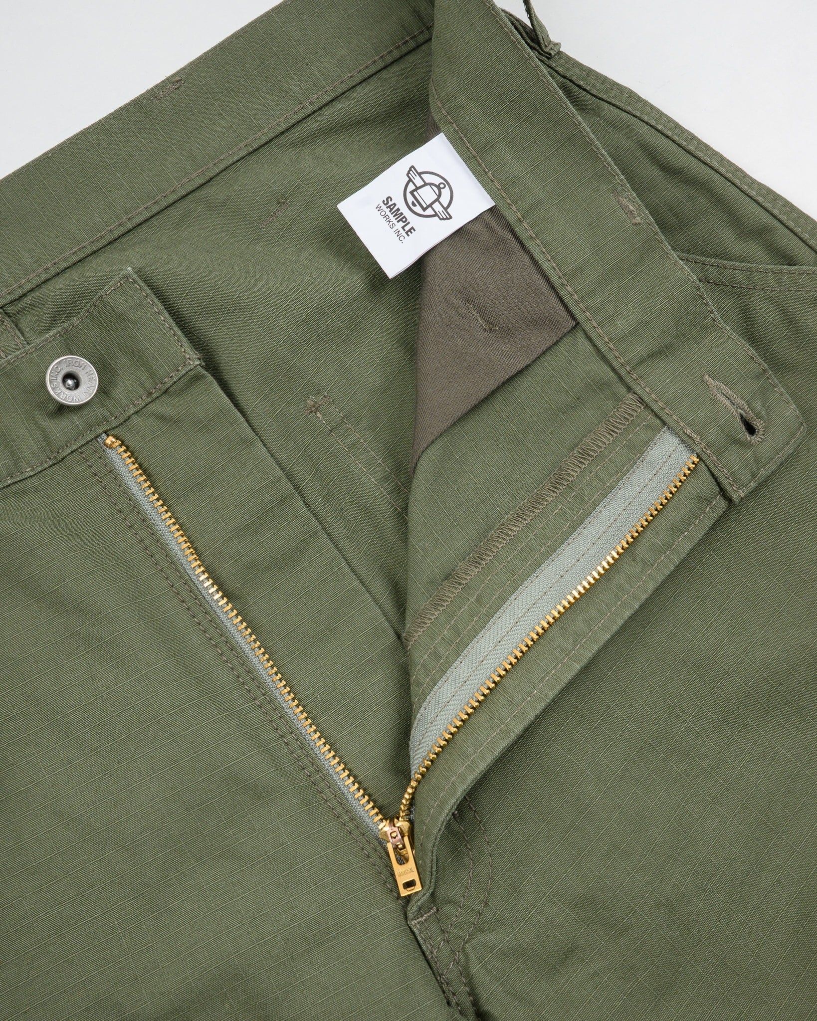 Olive pants front view laying flat closeup on open zipper