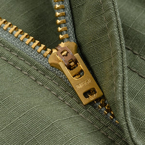 Olive pants laying flat closeup on zipper