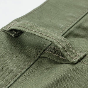 Olive pants laying flat closeup on belt loop