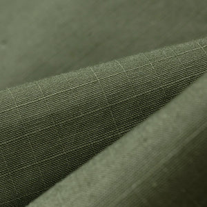 Olive pants laying flat closeup on fabric