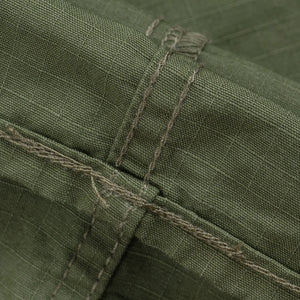 Olive pants laying flat closeup on stitching