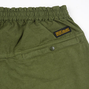 Olive mid length shorts back view laying flat closeup on snap pocket and black/yellow Iron Heart logo