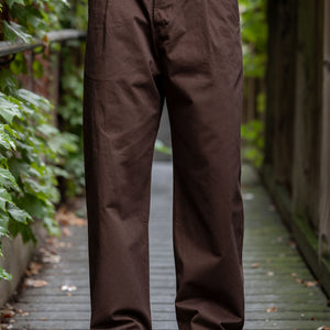 Hansen Garments Bobby Wide Pleated Trousers - Chestnut - model shot - front facing - foliage alleyway backdrop
