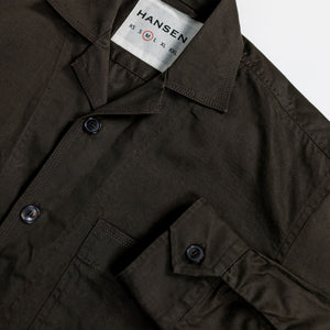 Hansen Garments Steffen Shirt Jacket - Coffee Drill - product shot - front facing - white background - detail shot of collar, button, sleeve, and brand tag