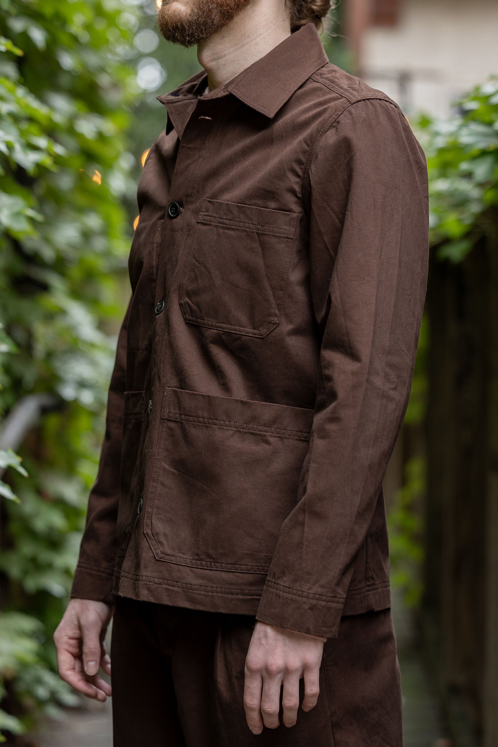 Hansen Garments Bendik Workwear Jacket - Chestnut - model shot - side facing - outside foliage background