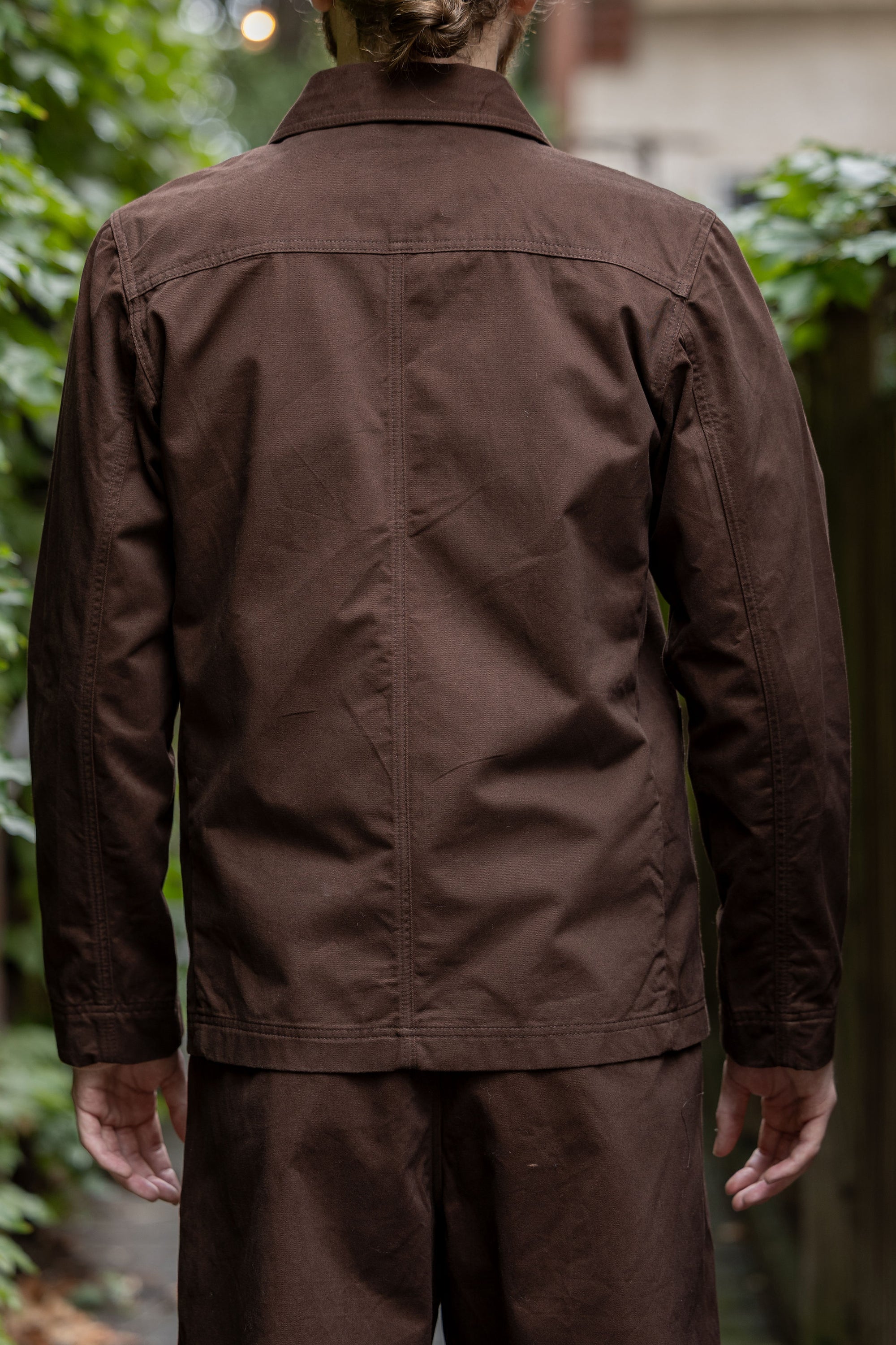 Hansen Garments Bendik Workwear Jacket - Chestnut - model shot - back facing - outside foliage background