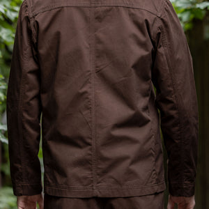 Hansen Garments Bendik Workwear Jacket - Chestnut - model shot - back facing - outside foliage background