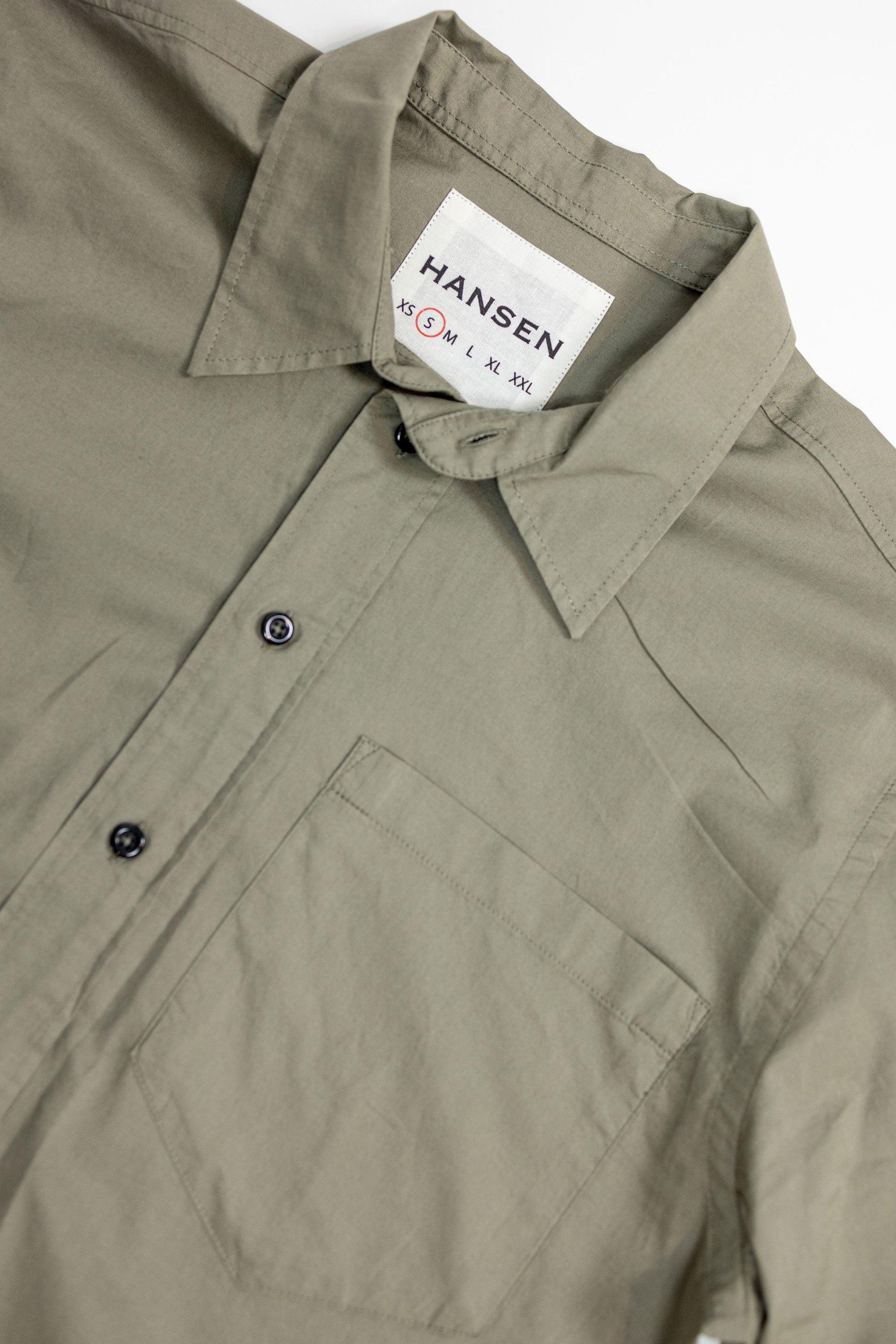 Hansen Garments Reidar Short Sleeve Shirt - Dry Oregano - product shot - front facing - white background - close up of collar, buttons, brand tag, and pocket