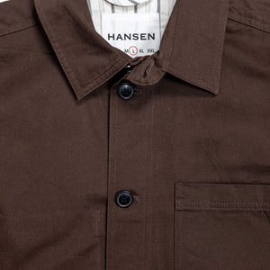 Hansen Garments Bendik Workwear Jacket - Chestnut - product shot - front facing - white background - close up detail of collar, buttons, and pocket.
