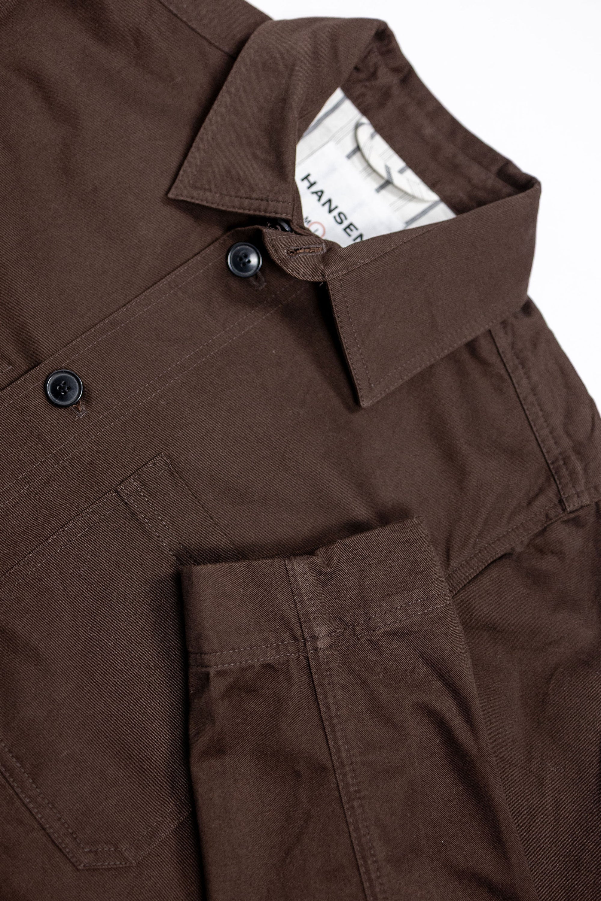 Hansen Garments Bendik Workwear Jacket - Chestnut - product shot - front facing - white background - close up detail of collar, buttons, pocket, and sleeve