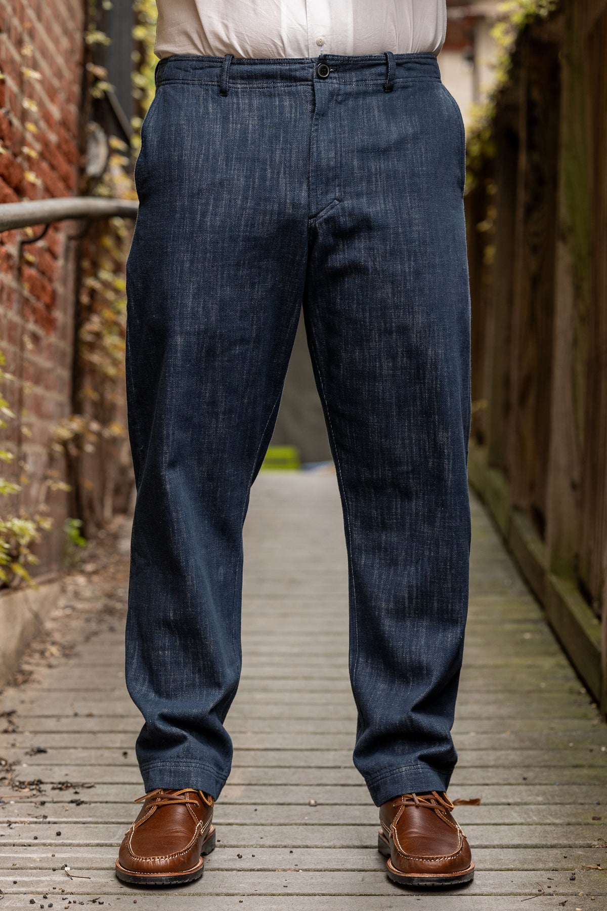 Hansen Garments Trygve Wide Cut Cropped Trousers - Denim Blue - model shot - waist down - front facing - brick & wood alleyway background
