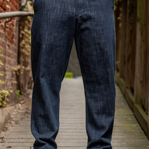 Hansen Garments Trygve Wide Cut Cropped Trousers - Denim Blue - model shot - waist down - front facing - brick & wood alleyway background