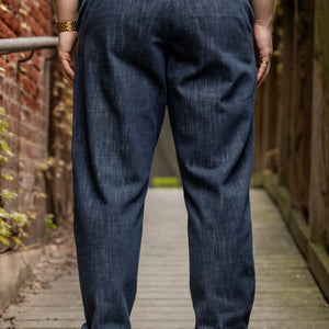 Hansen Garments Trygve Wide Cut Cropped Trousers - Denim Blue - model shot - waist down - back facing - brick & wood alleyway background