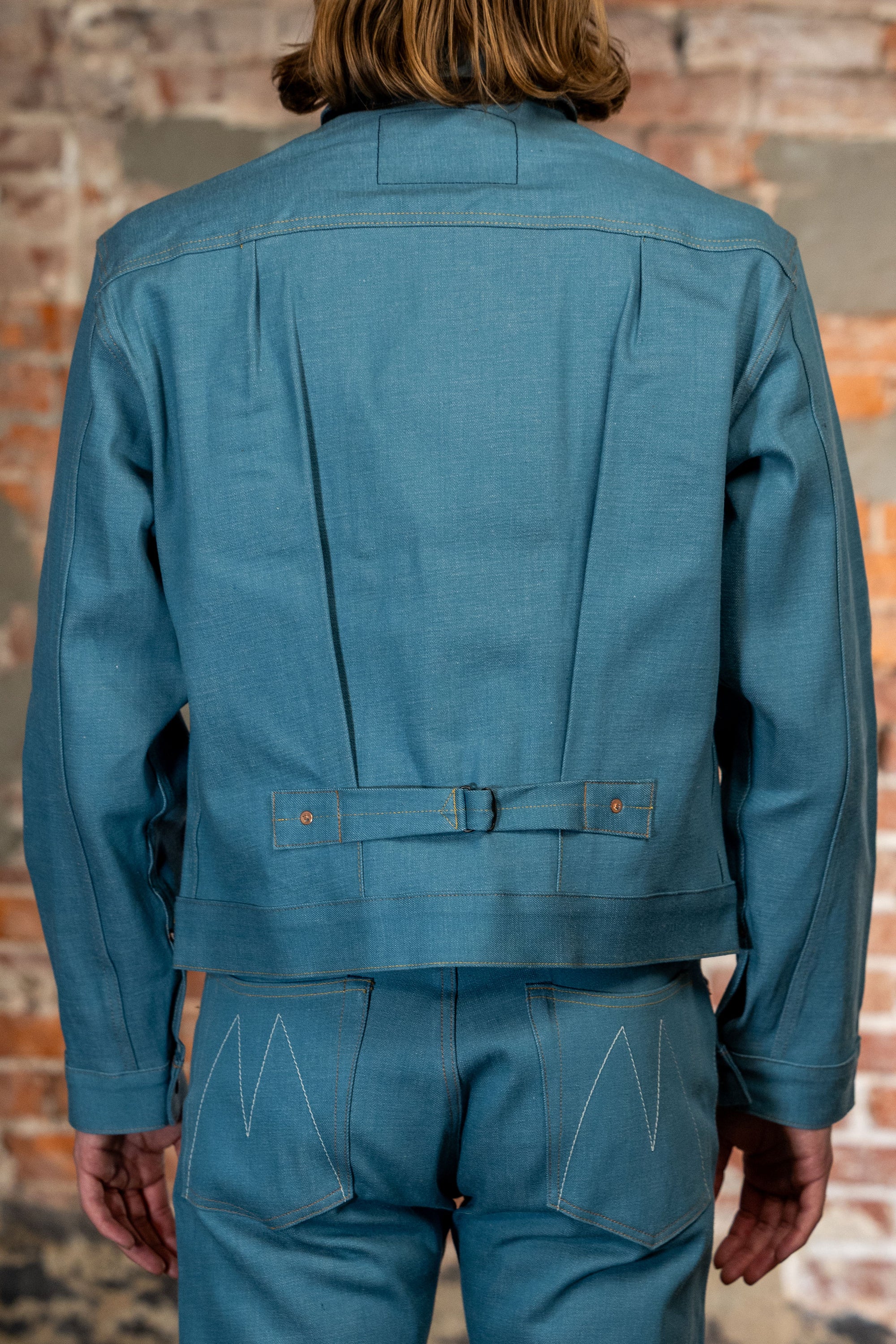 Light blue denim jacket back view on model
