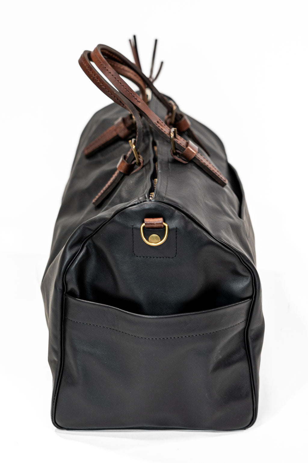 Black leather duffel bag with pockets and brown leather handles side view