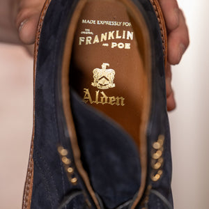 Navy blue suede cap toe boots close up on Alden and Franklin and Poe print on tan leather insole