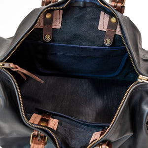 Black duffel bag with brown handles closeup navy pocket