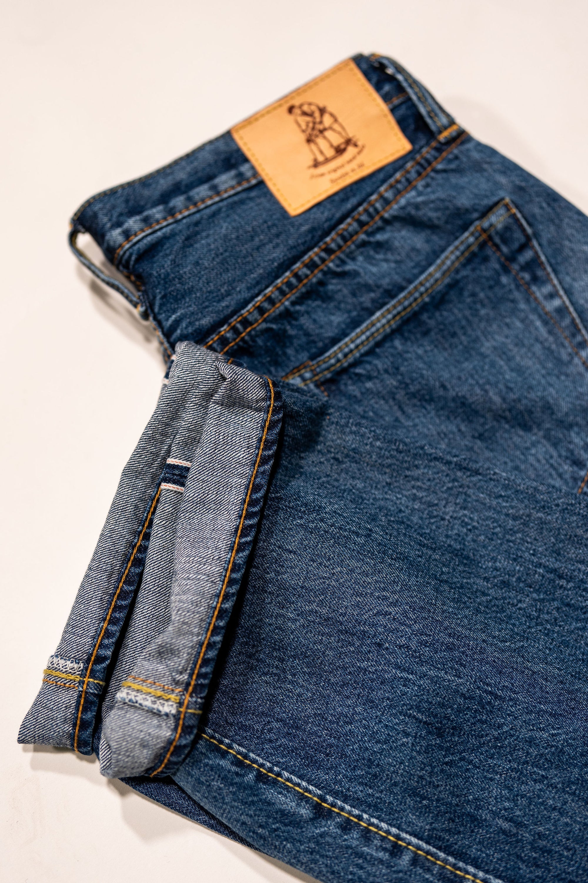 Pure Blue Japan USED-003-ID Regular Straight - 14oz Natural Used Wash Indigo x White. laid on side with close up of cuff detail