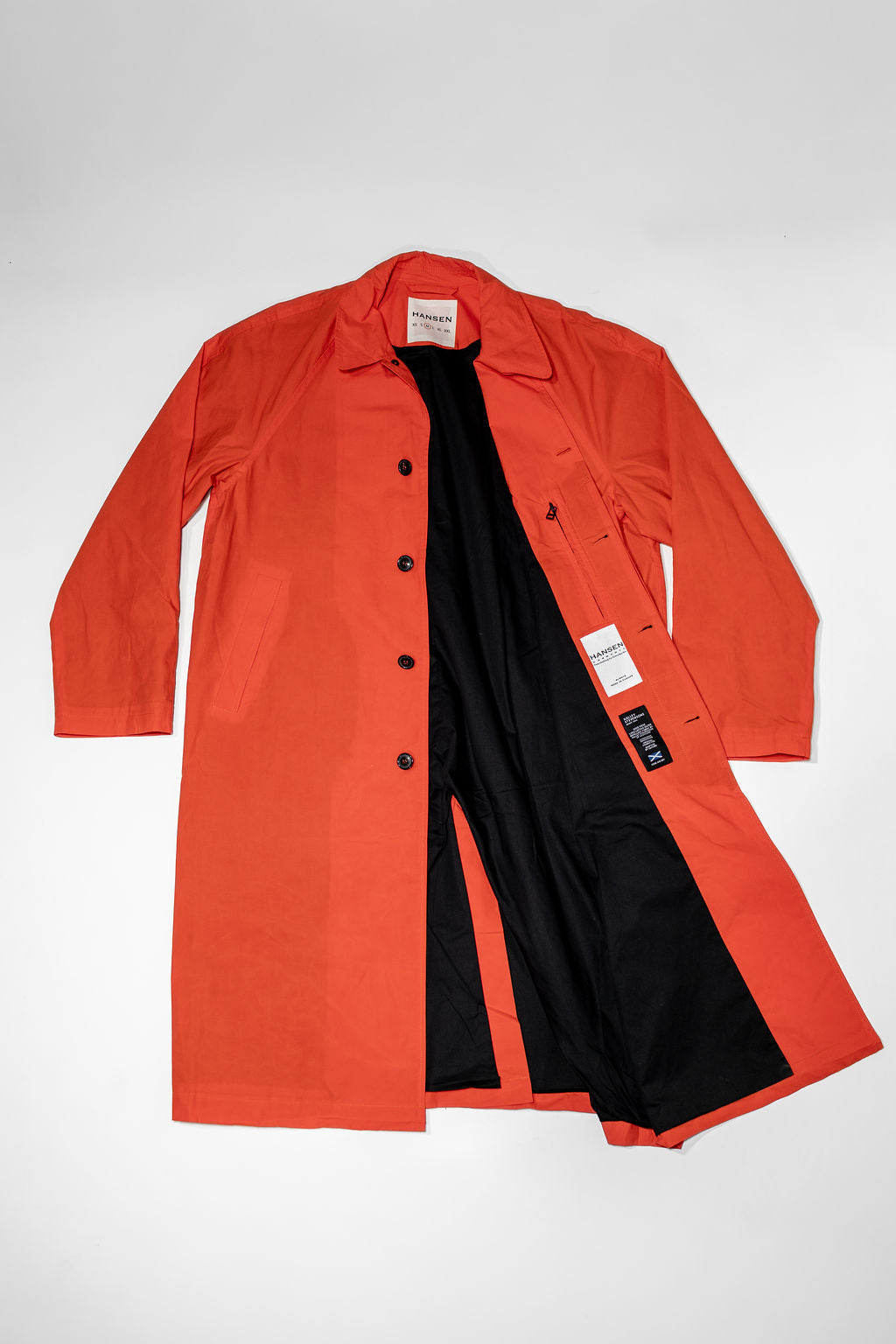 Hansen Garments Morten Long Coat - Waxed Orange laid flat unbuttoned 