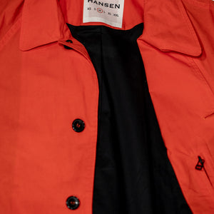 Hansen Garments Morten Long Coat - Waxed Orange laid flat. Details on buttons and open collar