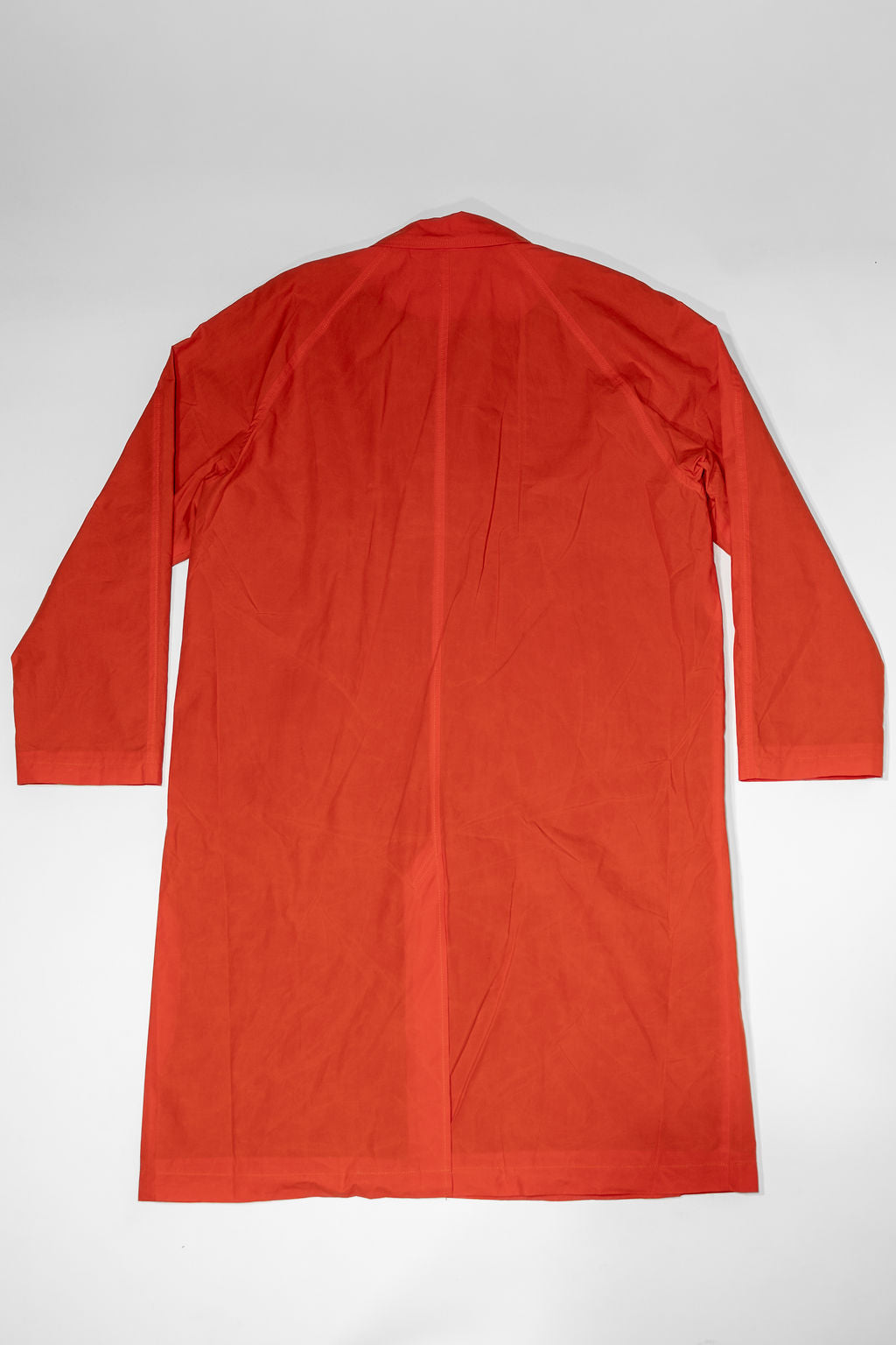 Hansen Garments Morten Long Coat - Waxed Orange laid flat from the back