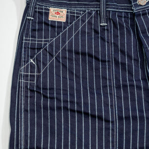 Navy striped fatigue pocket pants close up on full right front pocket with white/red Sugar Cane logo laying flat