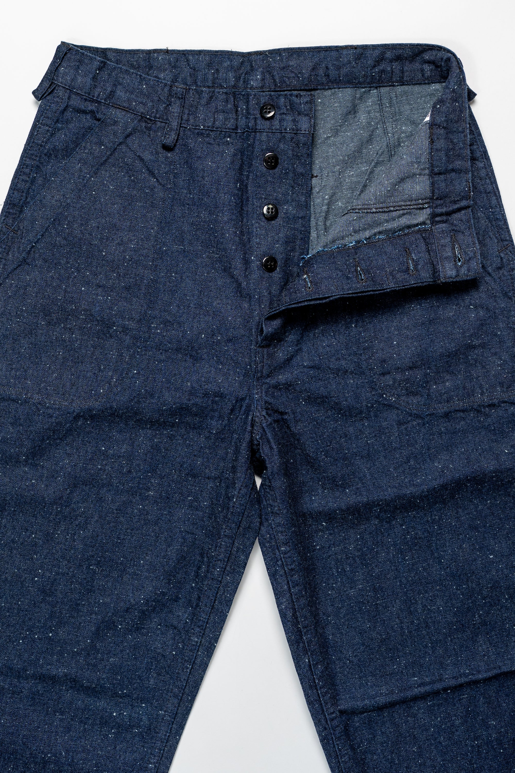 TCB Jeans Seamens Trousers - 10oz Neppy Denim Indigo One Wash. laid on back with buttons undone