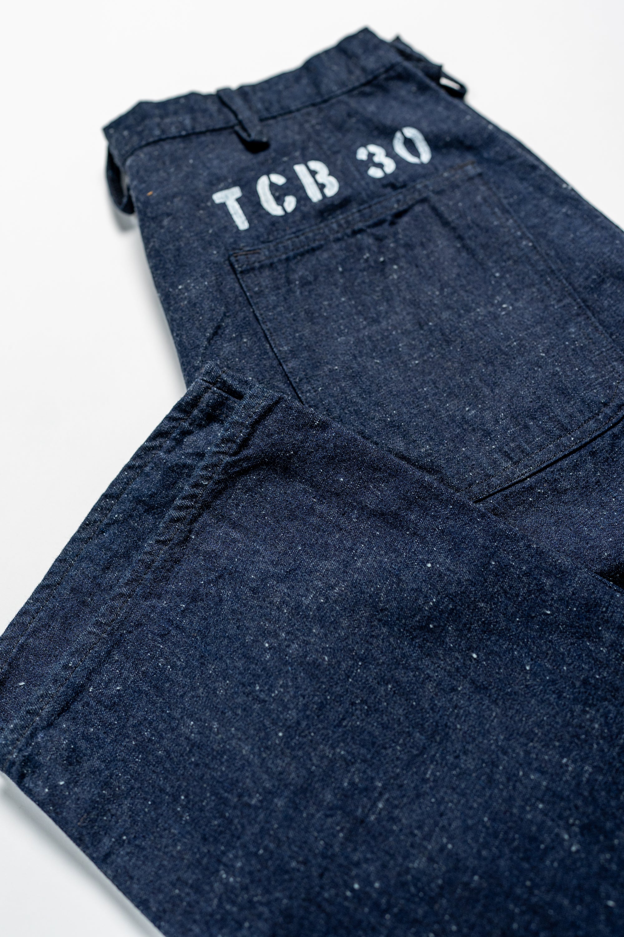 TCB Jeans Seamens Trousers - 10oz Neppy Denim Indigo One Wash. laid with back pocket showing with cuff showing