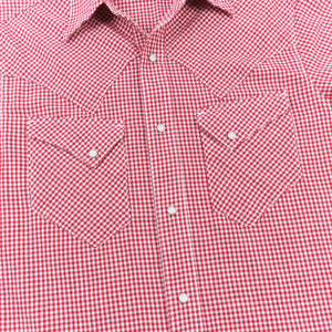 Red and white gingham western-style button-down shirt with two buttoned chest pockets, close up on chest laying flat