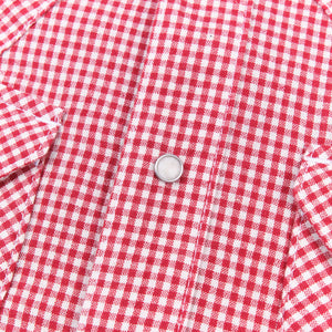 Red and white gingham western-style button-down shirt close up on snap laying flat