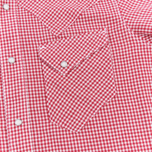 Red and white gingham western-style button-down shirt close up on left chest pocket laying flat