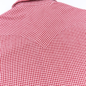 Red and white gingham western-style button-down shirt close up on back yoke laying flat