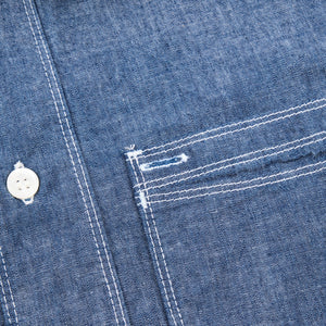 Shirt laid flat on white, from the front. Detail on left chest pocket. 
