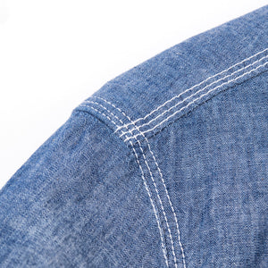Shirt laid flat on white, from the front. Close up on right shoulder, with triple  stitch. 